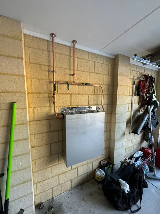 Whole house water filter installed in a garage