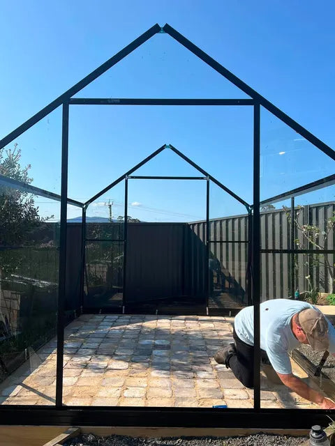A customer's Wintergardenz 8ft Wide Glasshouse mid-assembly on its timber base